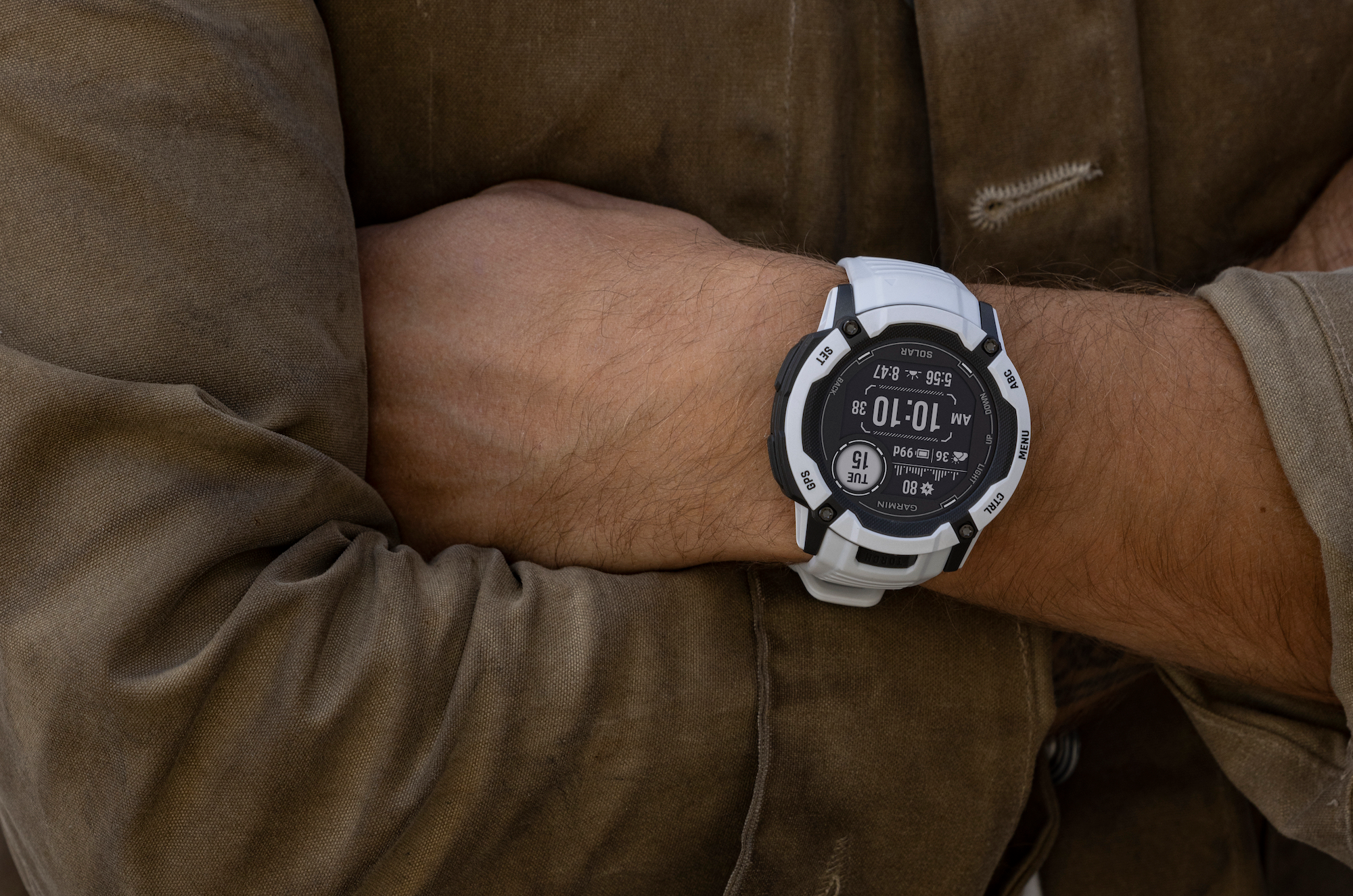 人手腕上戴着 Garmin Instinct 2X Solar 手表。