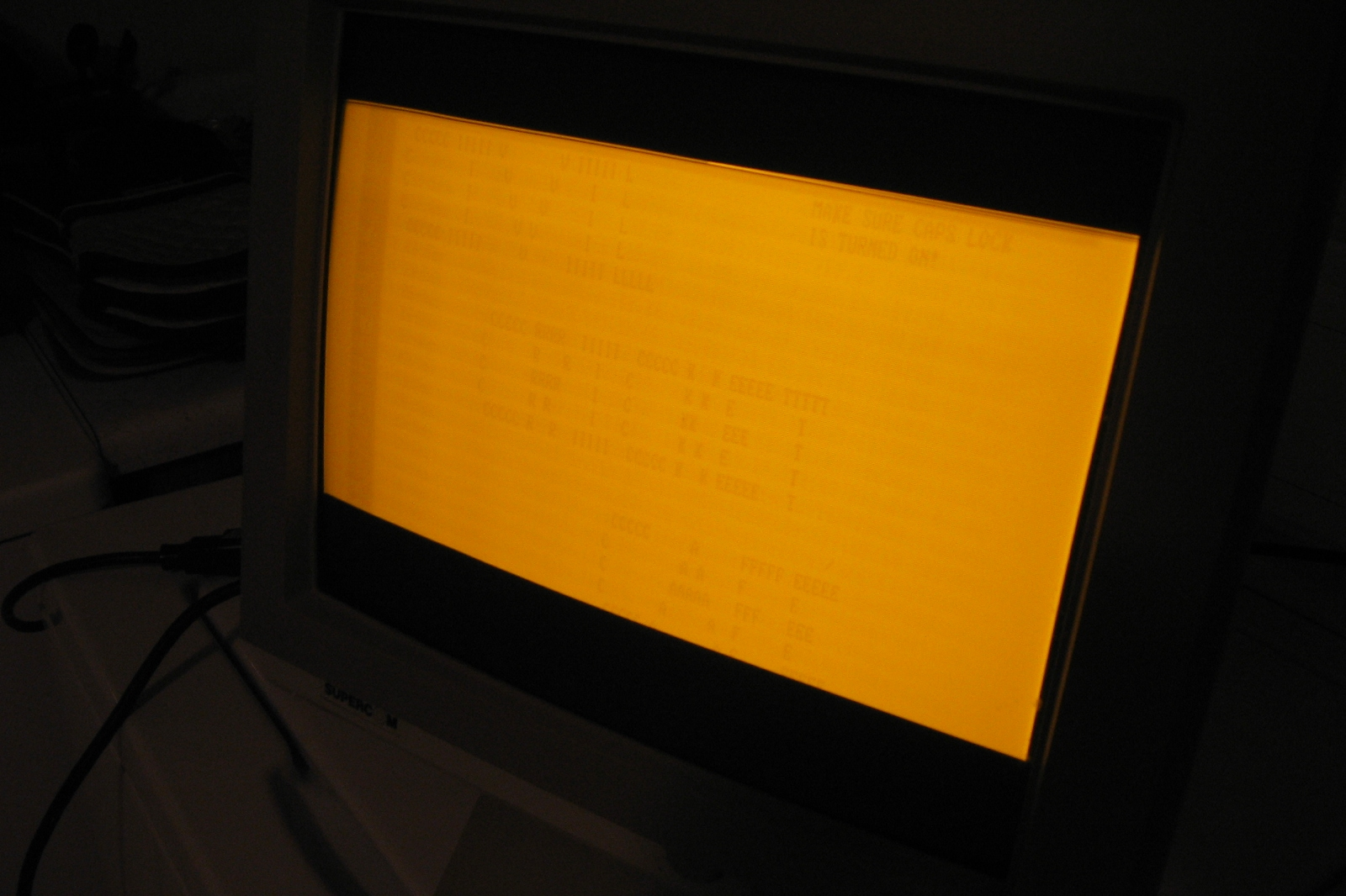 Phosphor burn-in (“screen burn”) visible on an amber monochrome CRT computer monitor.