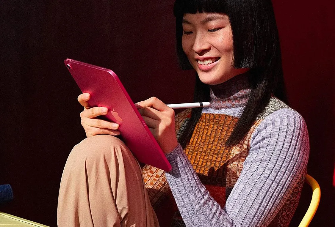 Uma mulher trabalhando em um Apple iPad 2022 com uma Apple Pencil.