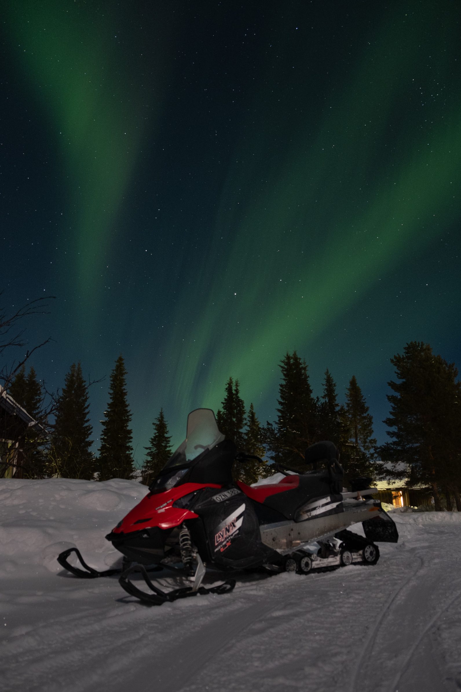 Un Lynx snowmobile alimentato a benzina sotto l'aurora boreale.