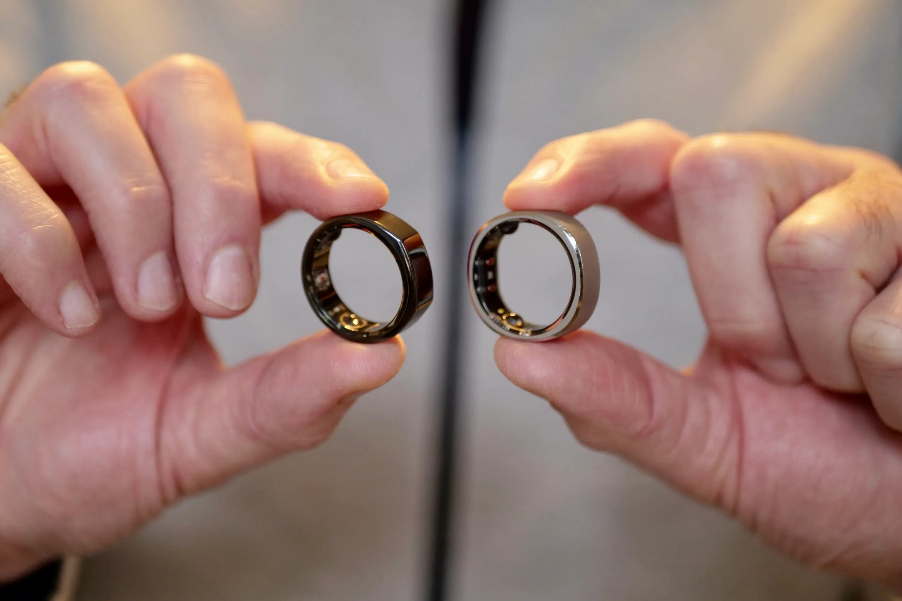 A person holding the RingConn Smart Ring and Oura Ring